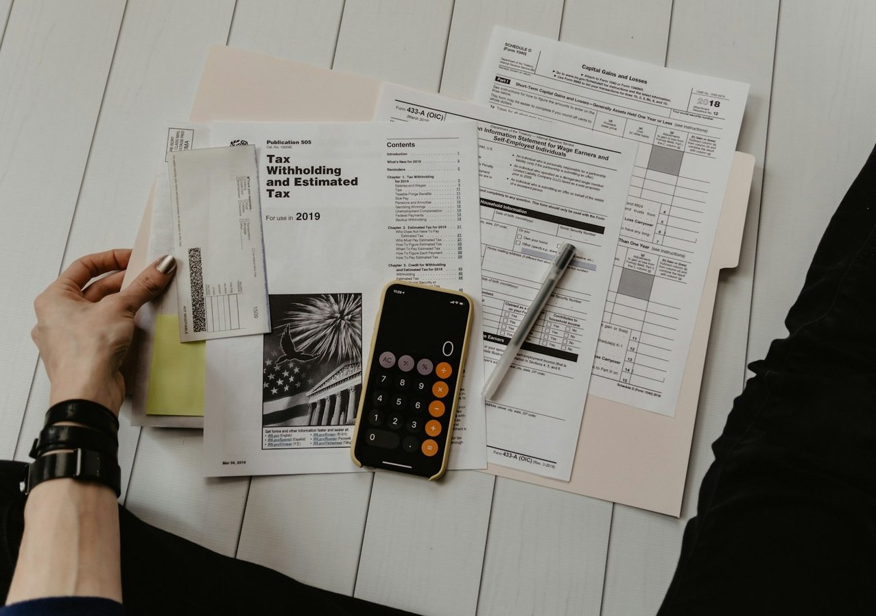 Hands arranging tax paperwork and folders